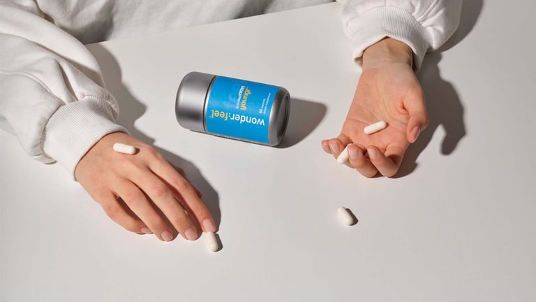 A Wonderfeel Youngr bottle and hands holding NMN capsules