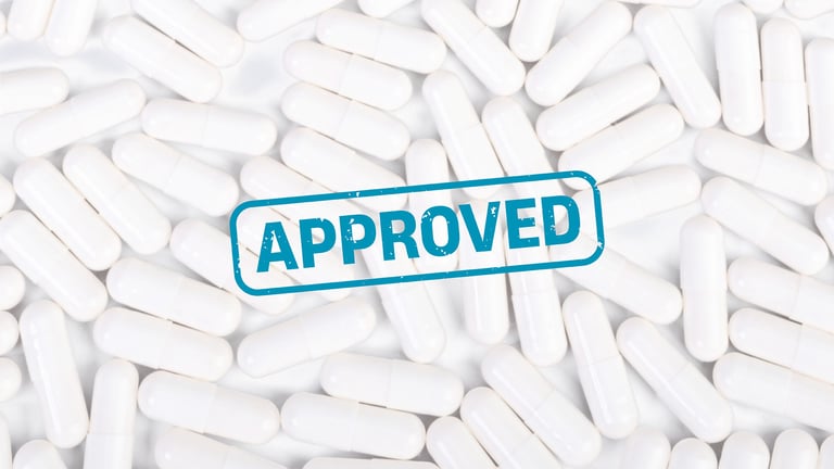 Cápsulas blancas con un sello azul de "Aprobado" encima de ellas