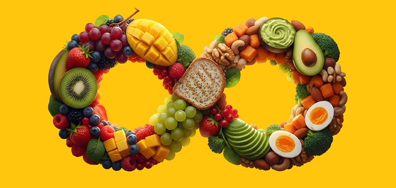 An infinity symbol made of colorful whole foods, including fruits, vegetables, nuts, and eggs on a yellow background, representing a balanced, sustainable approach to eating.